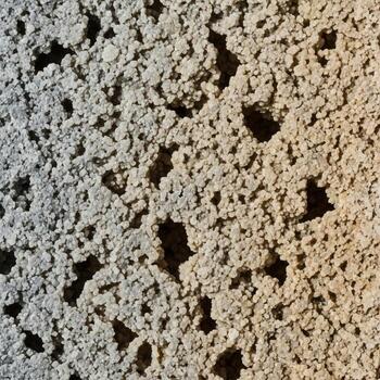 Close up textured abstract background with granular patterns and subtle color gradient from gray to beige and orange photo