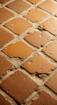 Close up view of a weathered terracotta tiled floor with a diamond pattern and visible grout lines photo