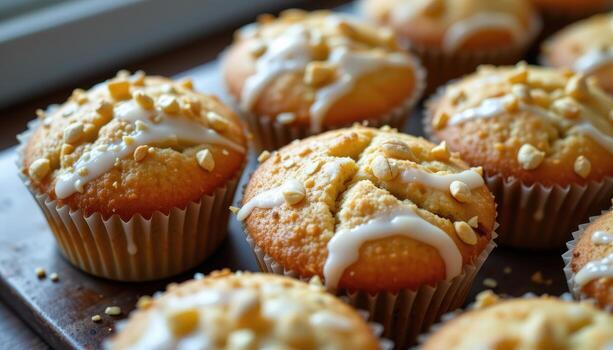 Lemon poppy seed muffins with thin sugar glaze, golden tops, and tiny seeds decorating the surface. photo