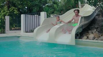 Mädchen und Teenager Spritzen in ein Schwimmen Schwimmbad von Wasser Folien im ein Hinterhof Rahmen mit Grün Bäume um video