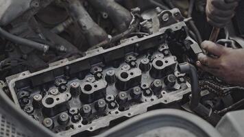 A mechanic is repairing a car engine. Close-up view of engine components, tools, and the hands of the mechanic. video