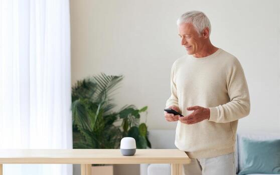 Senior man interacts with smart speaker using voice commands in a cozy indoor setting photo