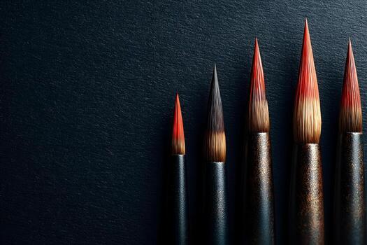 Set of artist paintbrushes with vibrant red tips arranged in a row on a textured dark background, showcasing the tools of creativity and artistic expression in a visually striking manner photo