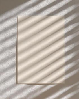 Minimalist a4 paper on smooth beige wall with soft light shadows photo