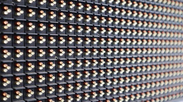 A side-angle close-up of a large LED display, showing the grid of lights and pixels in a pattern, symbolizing technology and digital communication. photo