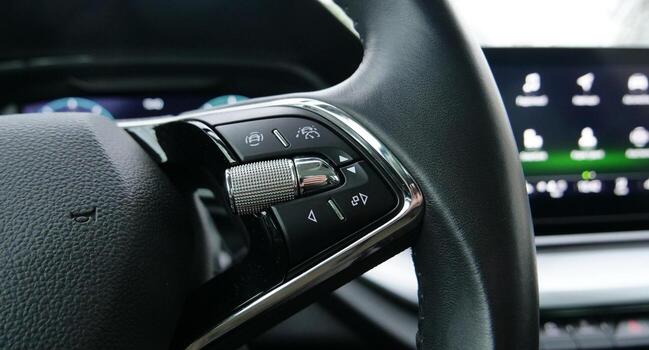 Blurred Display with Menu Icons Behind Steering Wheel with Interface Control Buttons on It Stock Photo