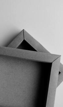 Square Cardboard Boxes One on Another on a White Surface Vertical Monochrome Photo. Same Craft Souvenir Boxes Isolated on White photo