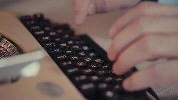 fechar acima do homem digitando em retro máquina de escrever com vintage chaves e suave iluminação video