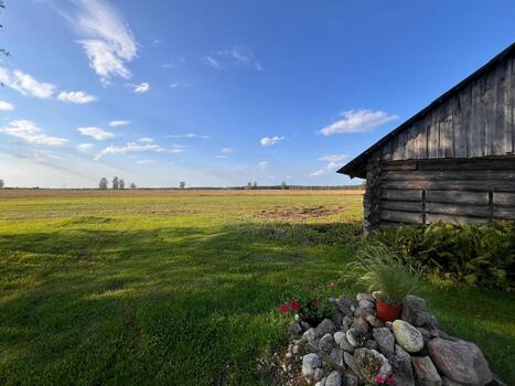 Rustic Wooden Structure with Open Field and Sparse Trees photo