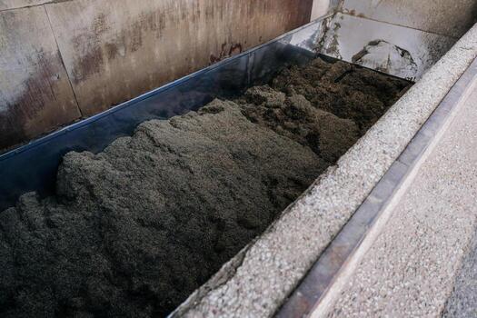 Large Rectangular Container with Dark Material in Industrial Setting photo