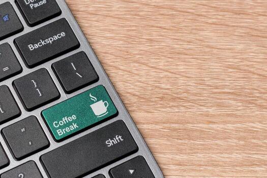 Computer keyboard with coffee break button on wooden background. Keyboard with green key Coffee break symbol. Copy space. photo