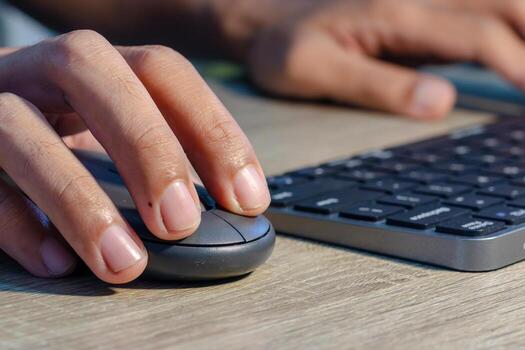 Close up view of male hands on computer keyboard and mouse photo