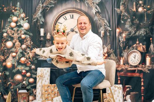 Dad lifts son in playful airplane pose in a festive Christmas setting photo