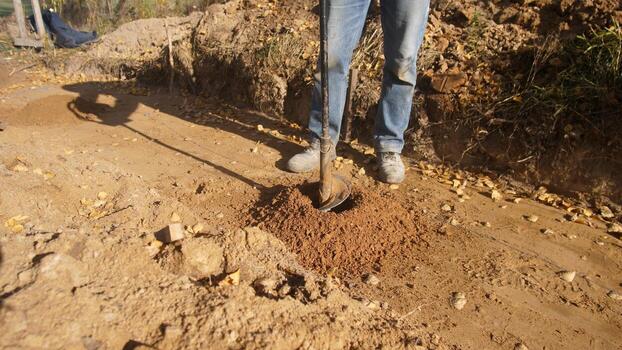 workers drill posts, team members engaged in drilling and installing roadside posts effectively, construction personnel collaboratively undertake drilling and placement of roadside posts photo