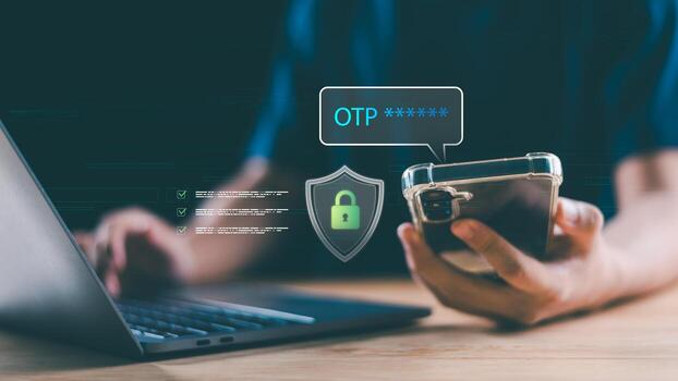 A person uses OTP verification on a smartphone to securely log in on a laptop, showcasing digital identity protection through two-factor authentication and modern cybersecurity practices. photo
