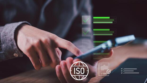 Hand using smartphone with ISO badge and digital checklists, illustrating quality assurance, compliance with standards, approval flows, performance rating, value control, regulation, evaluation photo