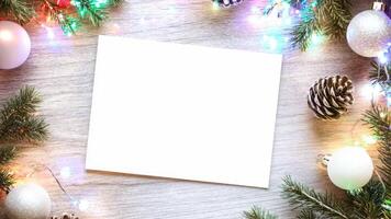 jul tom kort rustik skrivbord. vit hälsning kort flå lägga, topp se med Semester dekorationer. ram falsk upp med Plats för text. tömma papper ark. säsonger hälsningar. mall. företag video