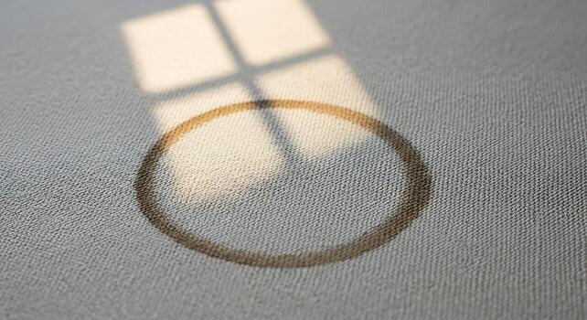 Sunlight Casting Shadow of Window Frame and Circular Object on Light Textured Surface photo