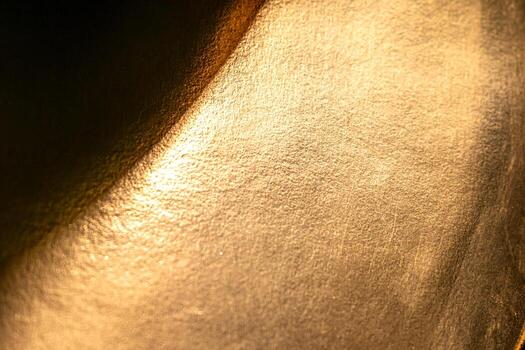 Golden background of an authentic image of an object, zoom on its texture for background and concept, yellow photo