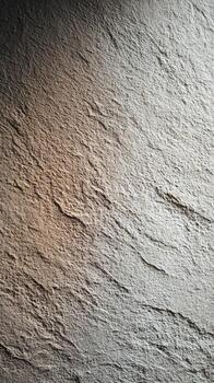 Gray textured concrete wall surface creating an abstract backdrop with rough stone-like patterns, showing natural light and shadow gradients for architectural background design photo