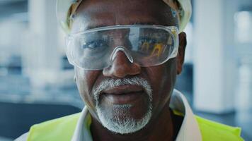 uma maduro africano americano homem, vestido dentro profissional vestuário com segurança engrenagem, com confiança carrinhos dentro uma moderno corporativo escritório. ele incorpora a empreendedor espírito do uma bem sucedido gerente. video