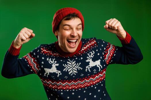 Dancing Holiday Spirit Indoors with a Cheerful Man in a Festive Sweater and Red Hat Against a Green Background Emphasizing Joy and Festive Vibrancy photo