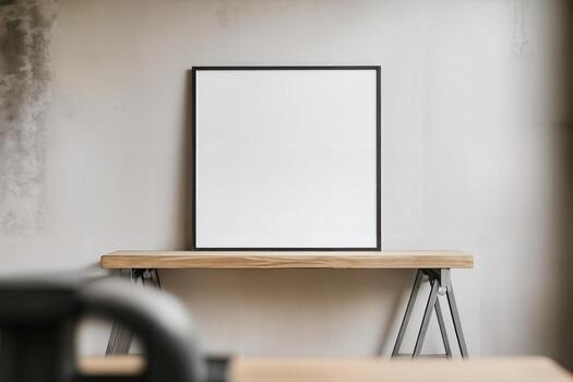 Industrial Poster Mockup on a Wooden Table in a Minimalist Indoor Setting with Blank Frame for Custom Design Elements and Concrete Wall in the Background photo