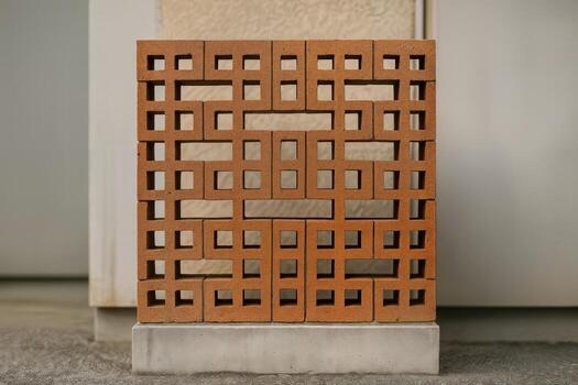 Pixelated Brick Lattice Pattern Displayed in an Urban Setting with a Symmetric Geometric Design on a Concrete Base Amidst Neutral Background photo