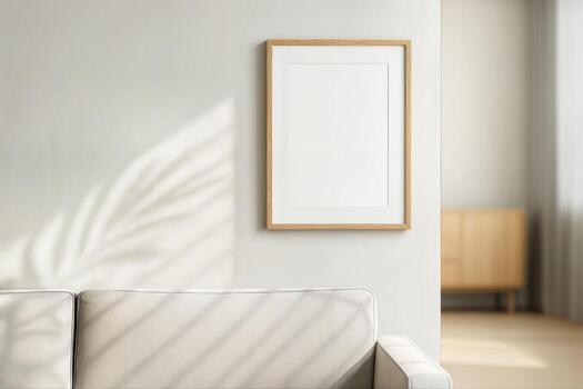 Modern Living Room Interior Featuring Minimalist Sofa and Empty Picture Frame on Neutral Wall with Soft Natural Light and Shadow Patterns photo