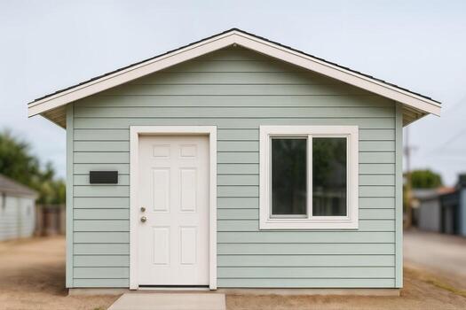 Garage Transformed Into Home Studio With Minimalist Design And Light Blue Exterior, Featuring A Single Door And Window In An Outdoor Setting photo