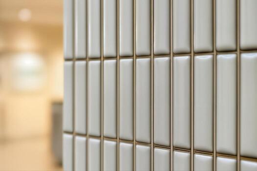 Modern Tile Wall Indoors Featuring Smooth White Rectangular Tiles Arranged Vertically With A Blurred Background Creating A Minimalist Aesthetic photo