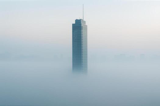 Skyscraper Emerging From Dense Fog During Dawn With Soft Light Creating A Serene Atmosphere In An Urban Landscape Highlighting Architectural Majesty photo