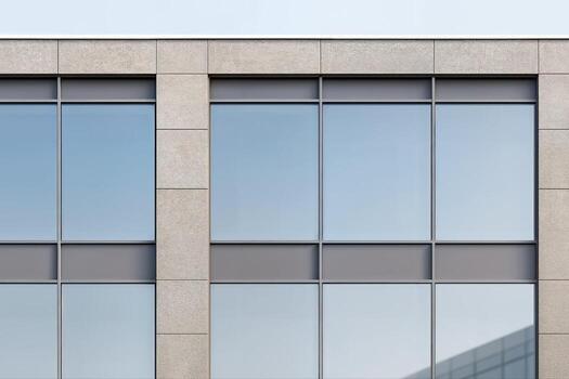 Modern Architectural Facade Featuring Symmetrical Windows and Concrete Panels in Cloudy Daylight Setting, Highlighting Urban Design Aesthetics photo