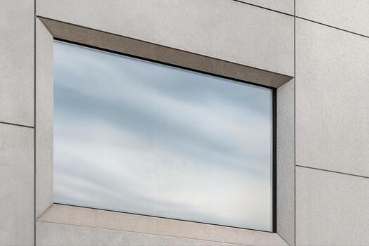 Building Facade Featuring a Large Glass Window Reflecting Clouds in a Modern Architectural Style During Daytime with Minimalist Design Features photo