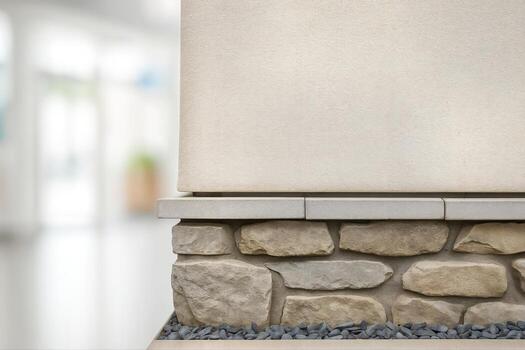 Stucco Wall Construction Featuring Stone Base and Smooth Finish in Bright Indoor Lighting With Shallow Depth of Field Creating a Modern Architectural Element photo
