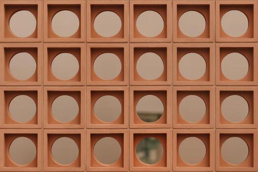 Terracotta Wall Pattern Featuring Round Cutouts Captured in an Outdoor Setting with Overcast Lighting Highlighting the Texture and Symmetrical Design photo