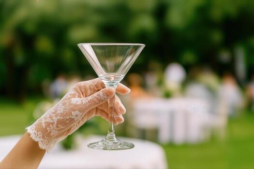 Lace Glove Elegance Showcased at an Outdoor Event with a Martini Glass in Hand with Blurred Scenic Background Creating a Soft and Sophisticated Atmosphere photo