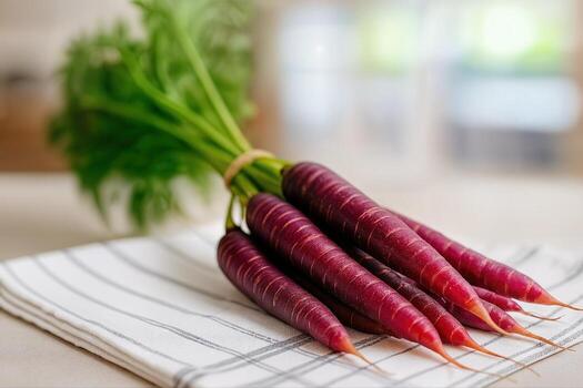 Purple Carrots Tied in a Bundle on a Striped Cloth in a Kitchen Setting With Shallow Depth of Field Showing Their Rich Vibrant Color photo