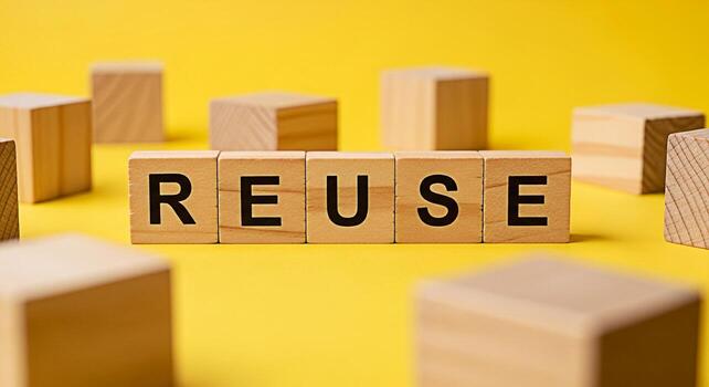 Wooden blocks spelling REUSE on a yellow background promoting sustainability and environmental awareness highlighting the importance of reusing materials to reduce waste and conserve resources in a br photo