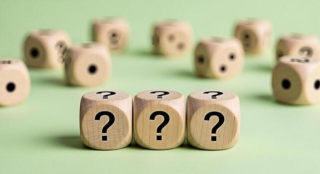 Three wooden dice displaying question marks on a light green surface representing uncertainty and the need for answers in business decisions and problemsolving creating a sense of curiosity and challe photo