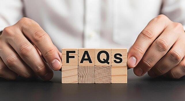 Closeup of hands arranging wooden blocks spelling FAQs on a dark surface symbolizing frequently asked questions and providing information with clarity and helpfulness in a professional setting photo