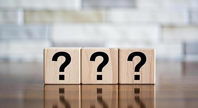 Three wooden blocks displaying question marks on a reflective surface against a blurred background representing uncertainty inquiry and the search for answers in a conceptual and thoughtprovoking comp photo