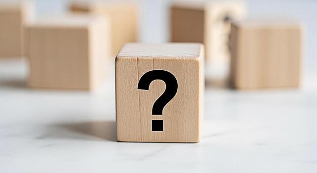 Wooden block displaying a question mark on a white marble surface symbolizing uncertainty and the need for answers in business and personal life creating a thoughtful and inquisitive atmosphere photo