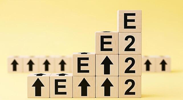 Wooden blocks displaying E and arrows ascend in a steplike formation on a yellow background symbolizing growth progress and the achievement of goals with a positive and motivational message photo