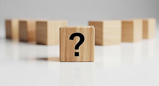 Wooden block displaying a question mark on a white surface standing out from blurred blocks in the background symbolizing uncertainty problemsolving and the search for answers in a minimalist setting photo