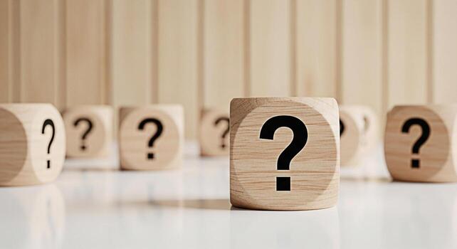 Wooden cubes displaying question marks on a reflective surface symbolizing uncertainty and the need for answers in a bright minimalist environment creating a sense of curiosity and problemsolving photo