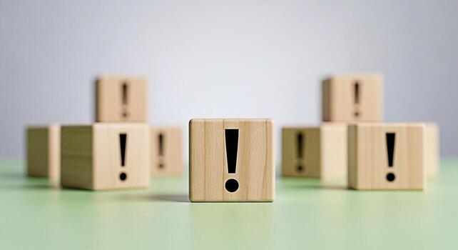 Wooden blocks displaying exclamation marks and blank faces arranged on a neutral surface symbolizing risk assessment and decisionmaking in a business or educational setting conveying a sense of urgenc photo