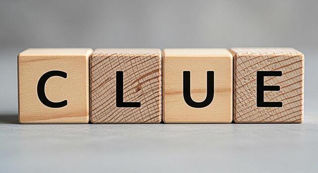 Wooden blocks spelling CLUE on a neutral surface suggesting mystery and investigation perfect for educational materials game design or conceptual illustrations about problemsolving and critical thinki photo