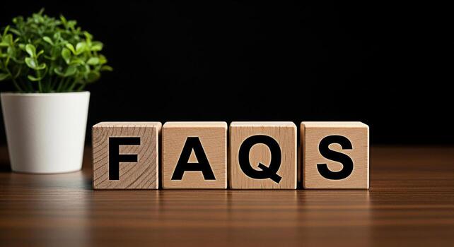 Wooden blocks spelling FAQs on a wooden table with a plant in the background representing frequently asked questions and information resources in a simple and accessible manner photo