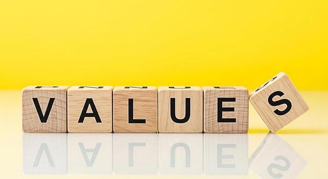 Wooden blocks spelling VALUES on a reflective surface against a bright yellow background representing core principles and ethical standards in a positive and engaging manner emphasizing importance photo